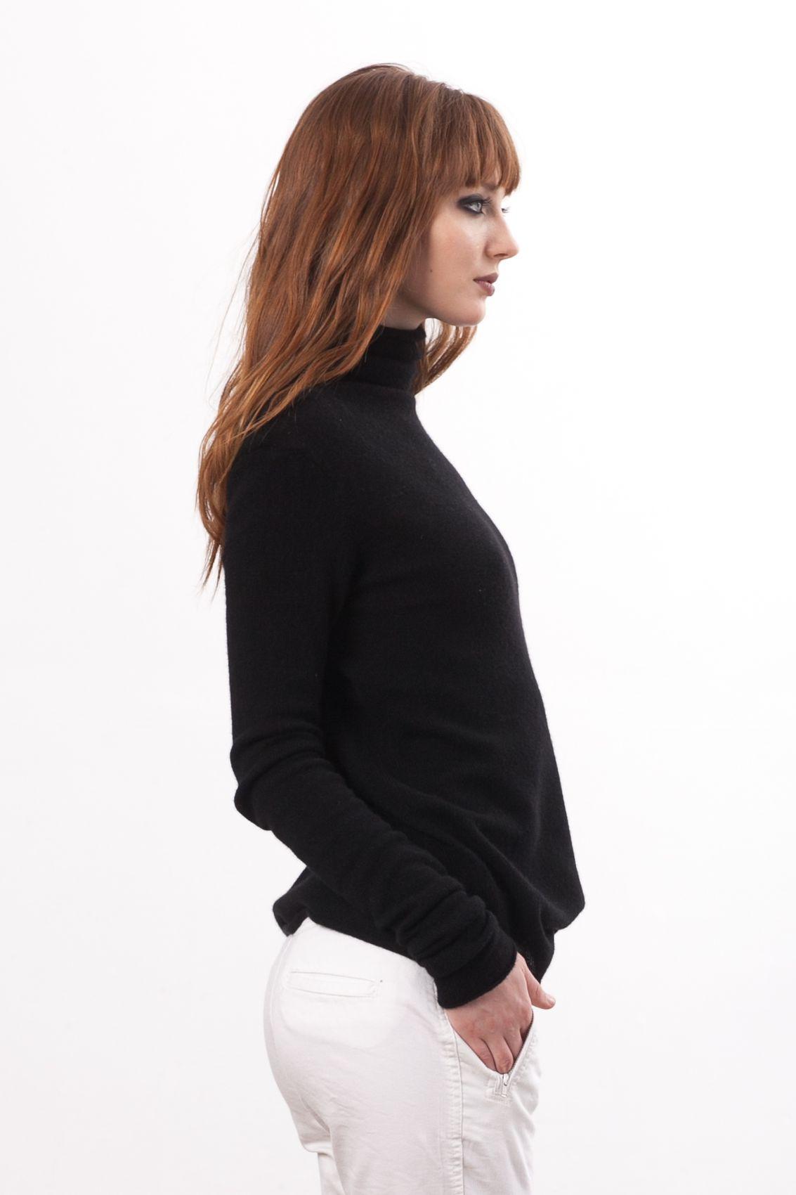 Radiating understated glamour, the KATE by Krista Elsta black cashmere turtleneck steals the spotlight in this image. The exquisite cashmere fabric drapes gracefully, providing a soft and indulgent touch to the skin. The turtleneck's sleek design is elevated by its deep black hue, creating a versatile garment that effortlessly transitions from day to night. Embrace the timeless appeal of this wardrobe staple, where comfort meets refined style in perfect harmony.