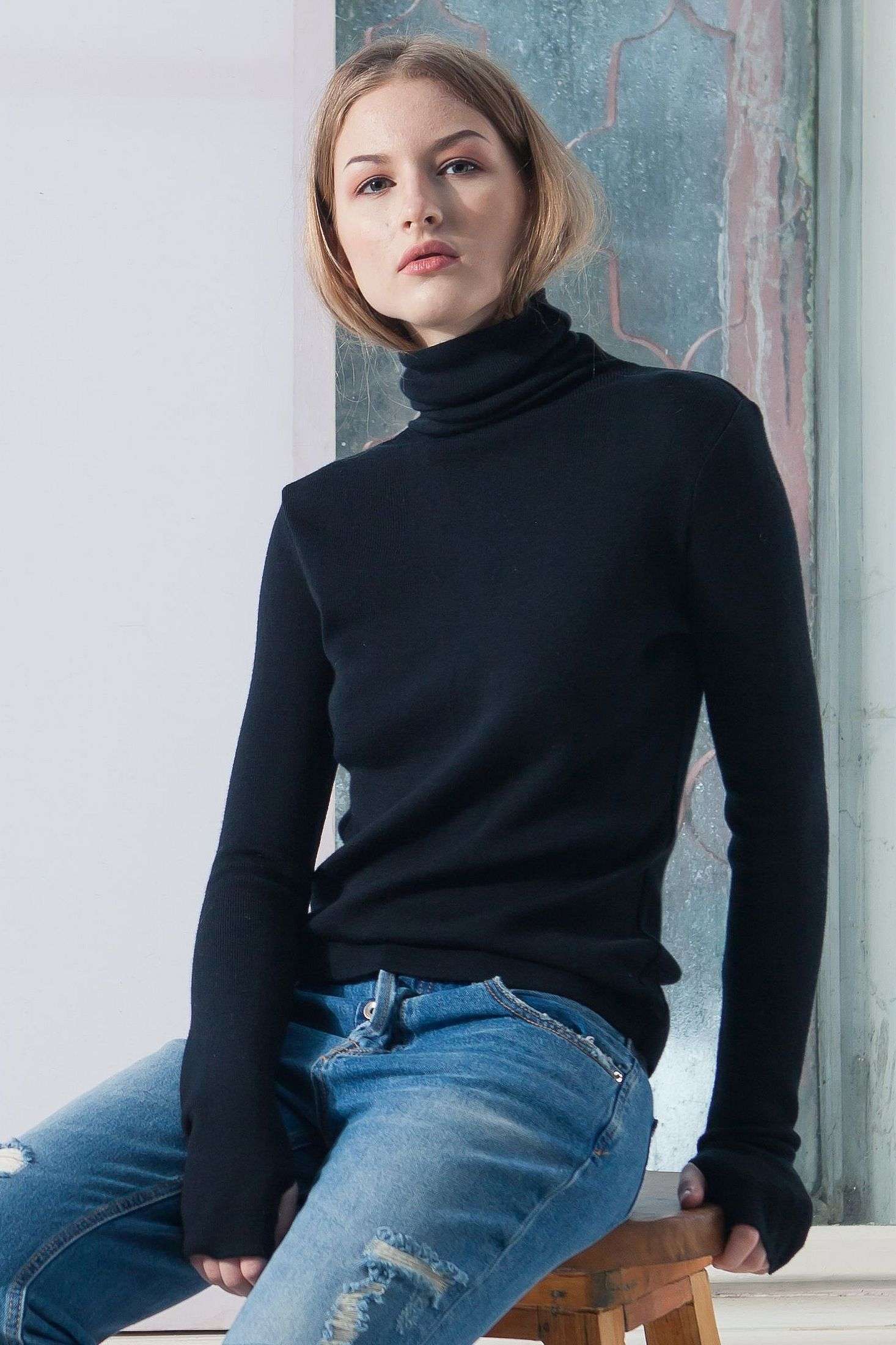 Young woman wears black turtleneck sweater ADA made from merino wool