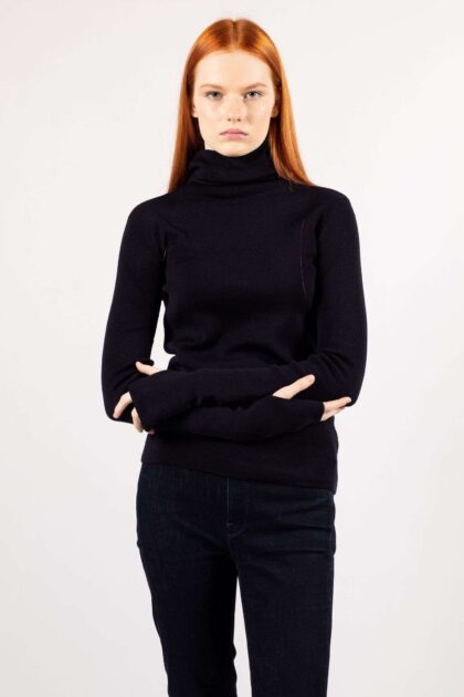 A young woman wears a fine knit turtleneck ADA in navy color