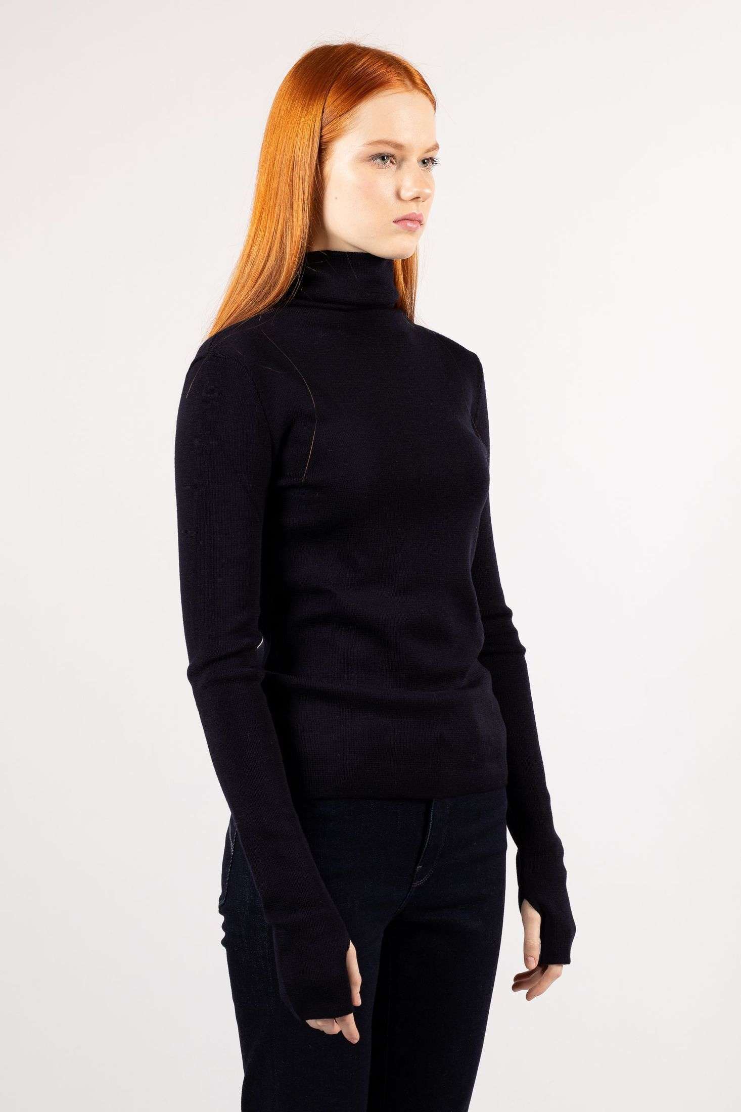 Witness a young woman showcasing style in the ADA fine knit turtleneck in a stunning navy shade.