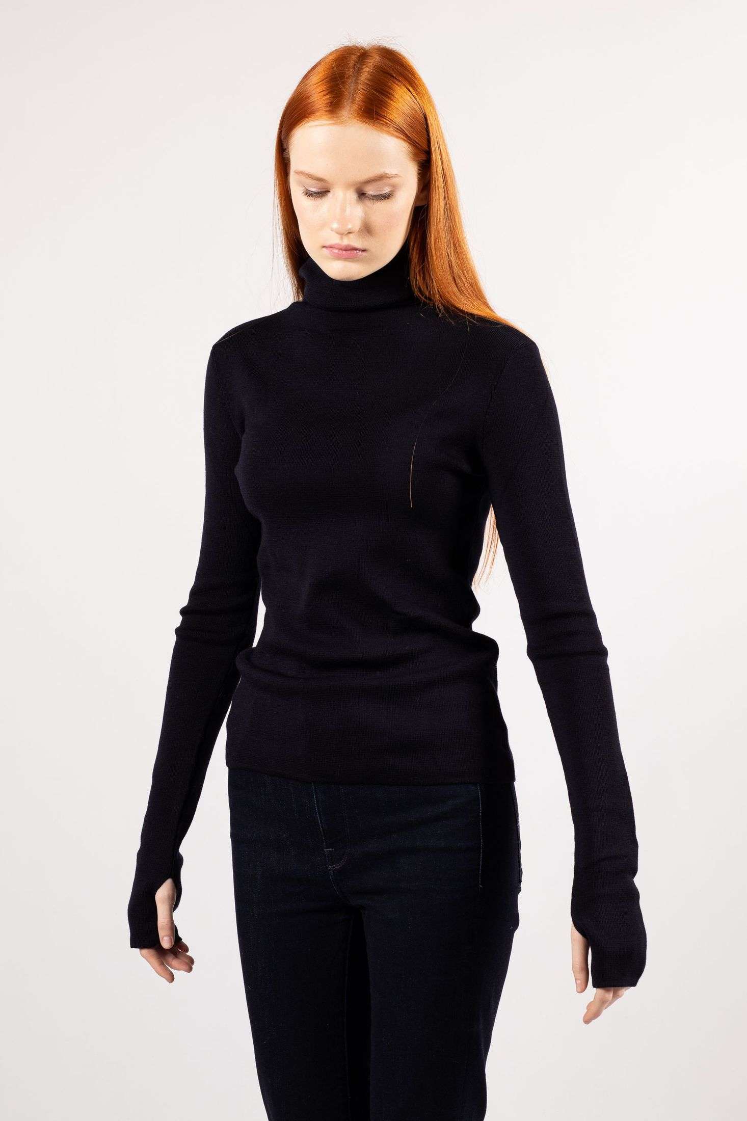 A youthful lady adorns herself in the navy-hued ADA fine knit turtleneck.