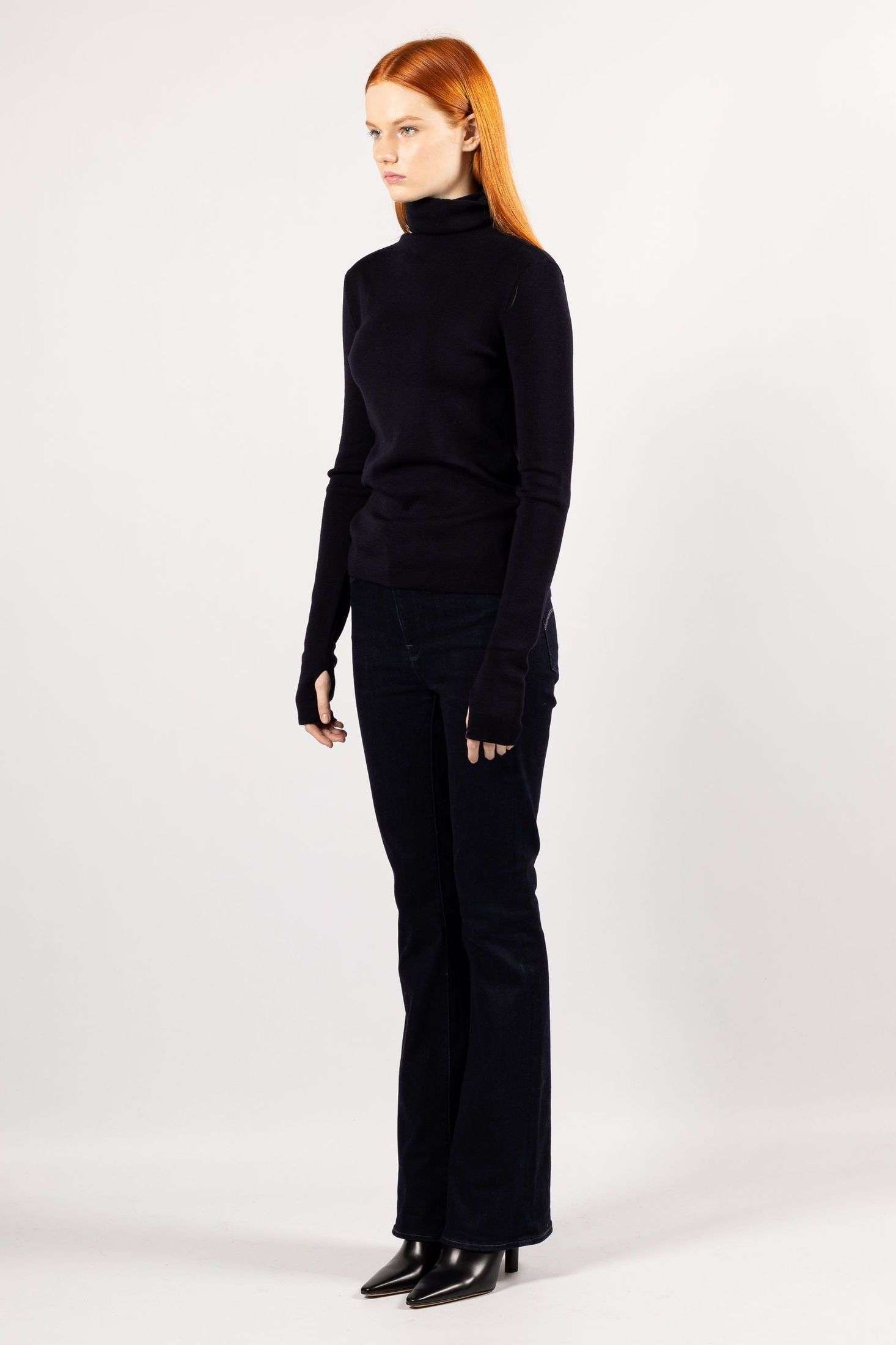 Experience the allure of the navy ADA fine knit turtleneck as modeled by a stylish young woman.